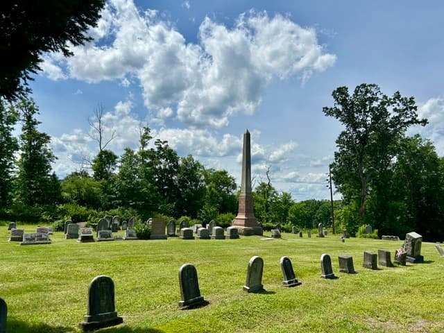 Cemetery monuments and headstones beneath a bright sky